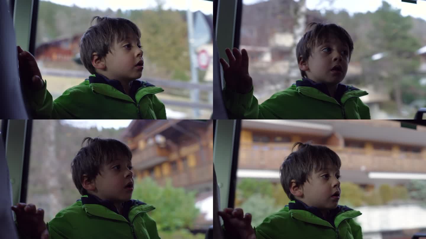 车内的小孩从乘客靠窗的座位上观察周围的环境。小男孩穿着雨衣乘坐公共交通工具
