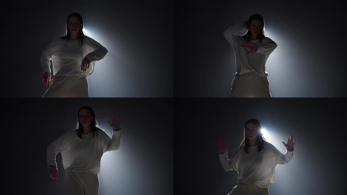 才华横溢的女人跳舞嘻哈背景与白光在演播室。为舞蹈学校的广告拍摄现代舞，舞者为音乐视频表演表达情感。