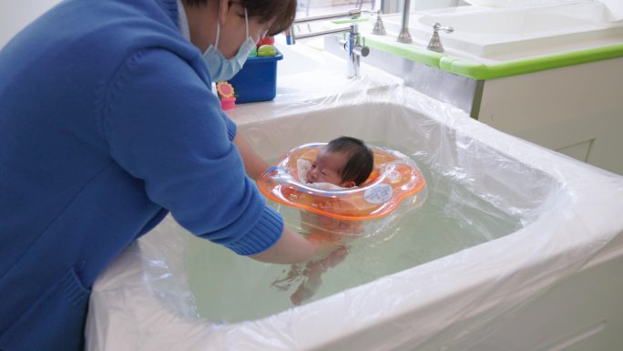 亚洲新生儿在教练帮助下游泳