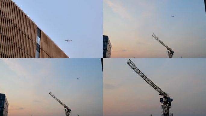 飞机飞过大楼 夕阳下塔吊