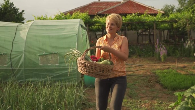 快乐的女农民拿着一篮子蔬菜