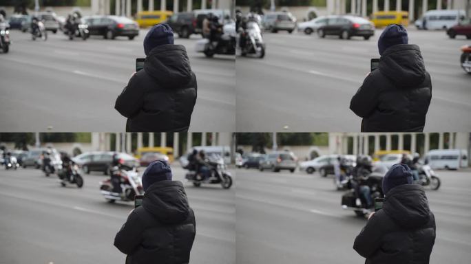 在街道边上穿着保暖夹克的孩子给一群骑自行车的人打电话。