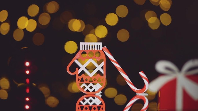 装饰圣诞玩具，手套和糖果手杖与模糊的灯的特写