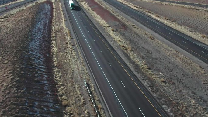 无人机拍摄的一辆半卡车和一辆白色拖车经过I-70在犹他州在一个阳光明媚的冬日