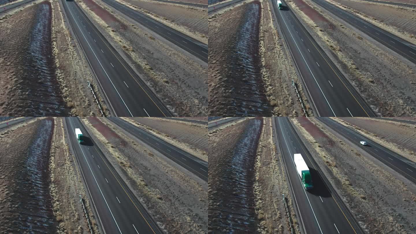无人机拍摄的一辆半卡车和一辆白色拖车经过I-70在犹他州在一个阳光明媚的冬日