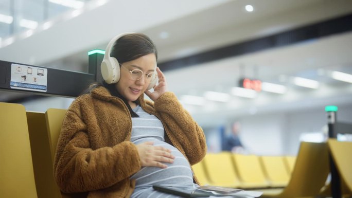 一名孕妇在机场候机时边听音乐边唱歌