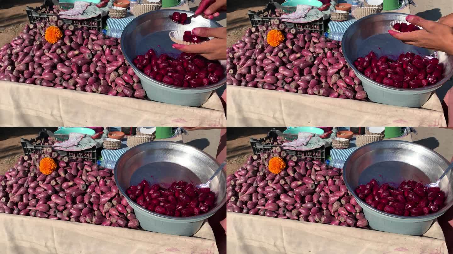 一堆红色多刺的梨(仙人掌的果实)在街上的手推车上出售。异国红色仙人掌果实的特写。一个卖仙人掌的摊位。
