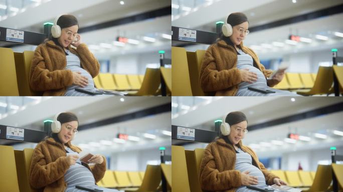孕妇在机场候机时揉着肚子听着音乐