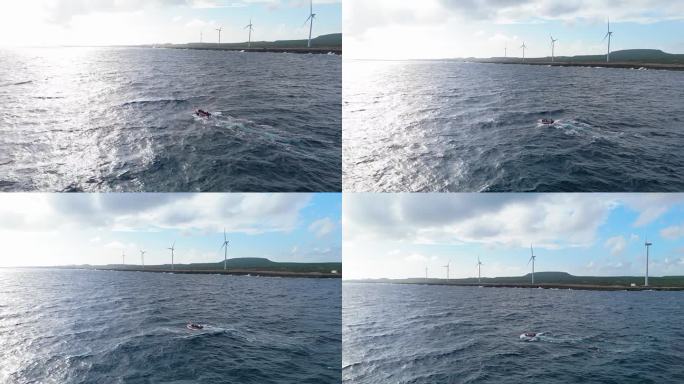 在库拉索岛的playa kanoa北部，渔民们用风车涡轮机在小船上勇敢地面对岩石海