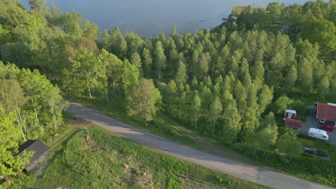 电影般的空中摄影小车倾斜显示度假屋和迷人的Illerasasjon湖，中午，瑞典
