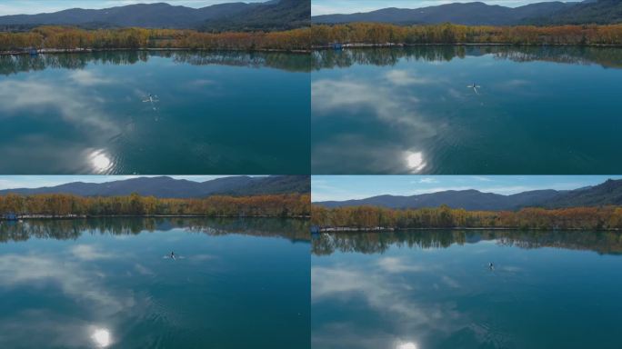 班约莱斯湖的秋天反射天空和太阳，因为划艇移动到岸边