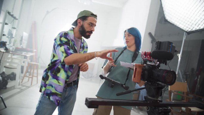 两名电影工作人员在一个创造性的电影项目上合作的慢动作肖像:有创意的年轻专业人士在观看拍摄场景回放时集