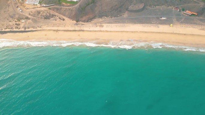 夏天的海景美丽的波浪，蓝色的海水在阳光明媚的日子。西班牙，加那利岛，埃斯昆佐海滩。海上鸟瞰图，热带自