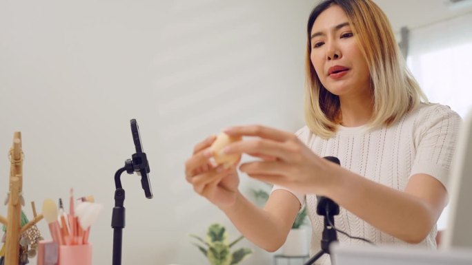 亚洲网红女性用相机拍摄化妆教程，在博客上直播视频频道，在网站或社交媒体上向订阅者播放。