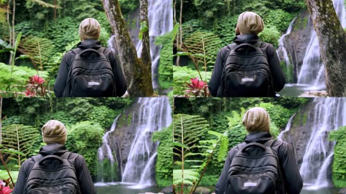成年男子在绿色自然中前往森林瀑布。一个不知名的年轻人走到丛林瀑布的旅行目的地。天堂岛之旅个人旅行的生