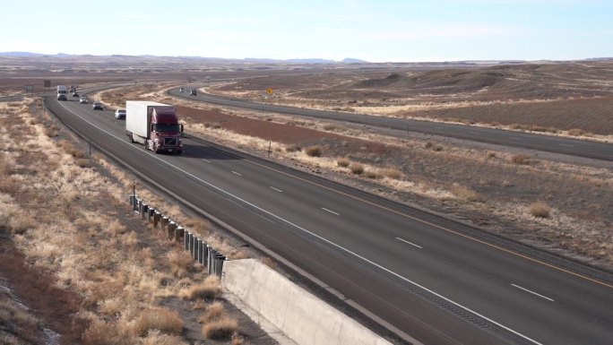 手持拍摄的半卡车与完美的白色拖车通过在双车道高速公路