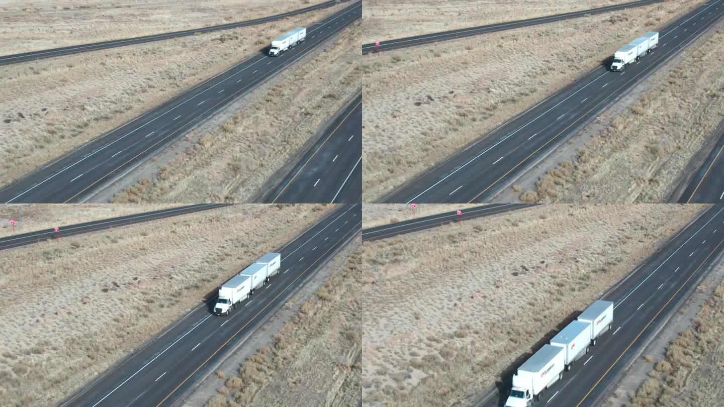无人机拍摄了一辆白色半挂车和三个拖车在冬季下午在犹他州的I-70上向西行驶