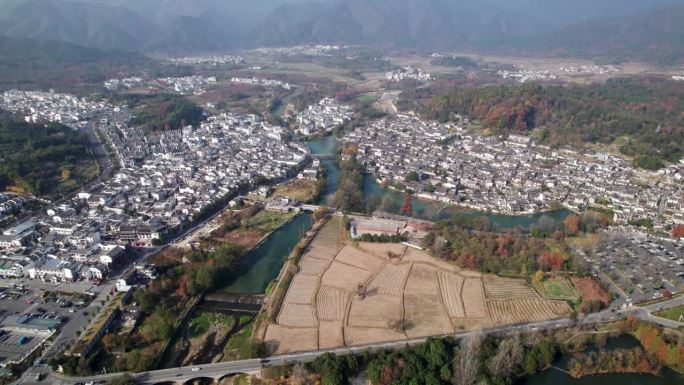 鸟瞰中国安徽宏村古村落。无人机在阳光明媚的秋日早晨拍摄传统村落，色彩缤纷的秋日农田，4k实时画面。