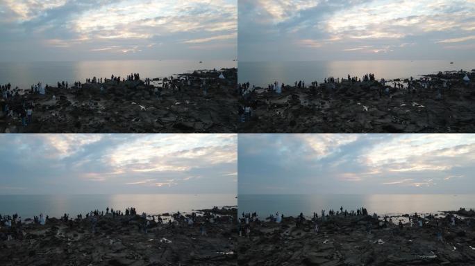一群人海边看日出看海海边礁石人群剪影背影
