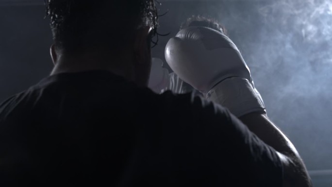 两名拳手在激烈的灯光下互相对视。战士戴着拳击手套面对对手的慢动作800 FPS