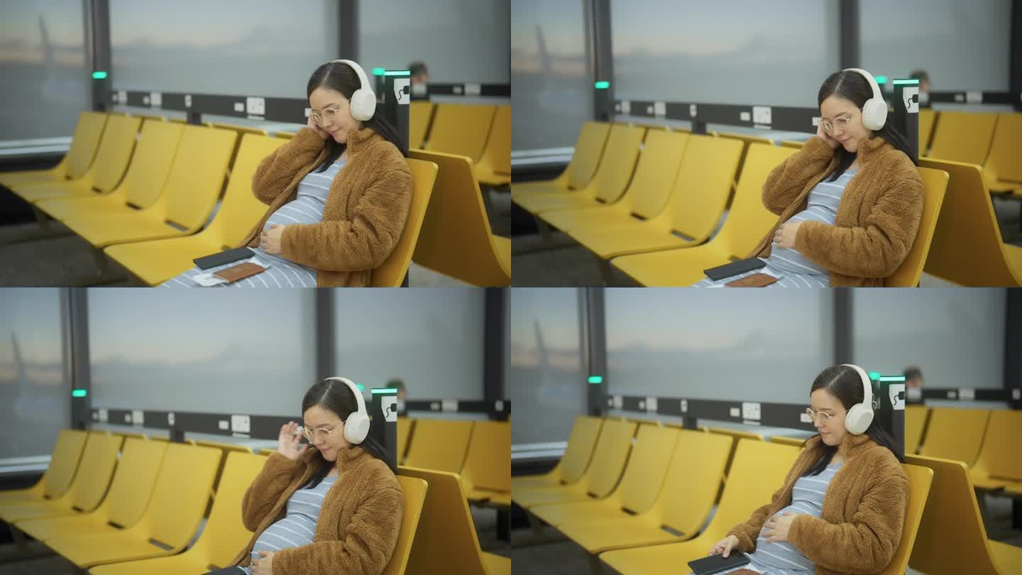 孕妇在登机口边听音乐边玩智能手机