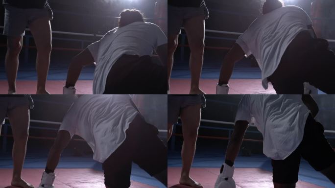拳手被对手击败后从地板上爬起来，拳台内人站起来的韧性主题