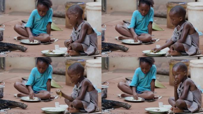 由于极度贫困、干旱和气候变化，肮脏、贫穷、营养不良的非洲黑人儿童。坐着吃玉米粥。五分之一的非洲儿童营