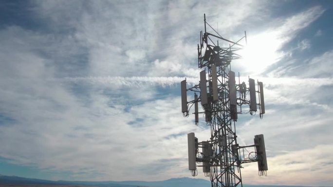 在一个阳光明媚的冬日，无人机在犹他州沙漠中靠近I-70的5G手机塔的近距离拍摄
