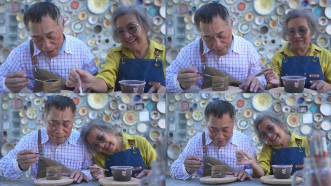 在陶艺作坊里，一对亚洲退休夫妇正在从事陶艺制作和泥画活动。