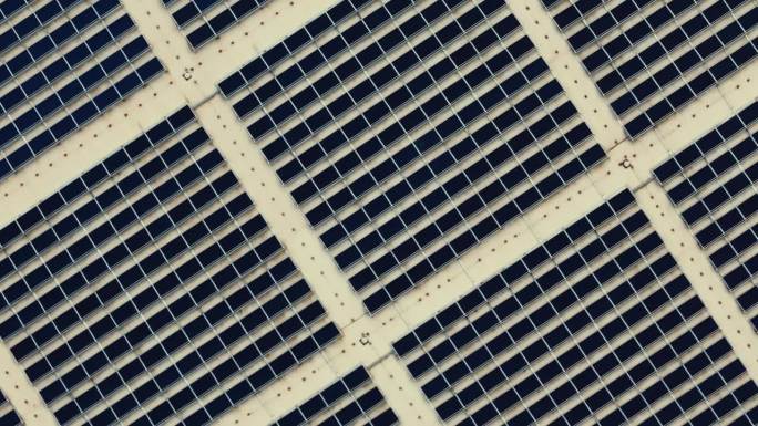 无人机拍摄的大型太阳能电池板阵列农场在商业配送仓库大楼