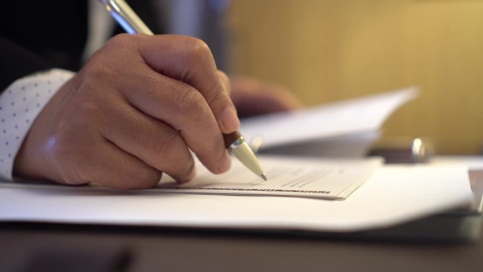 签署合同保险文件报告业务概念，商务经理手持笔阅读文件或文件文件的签名