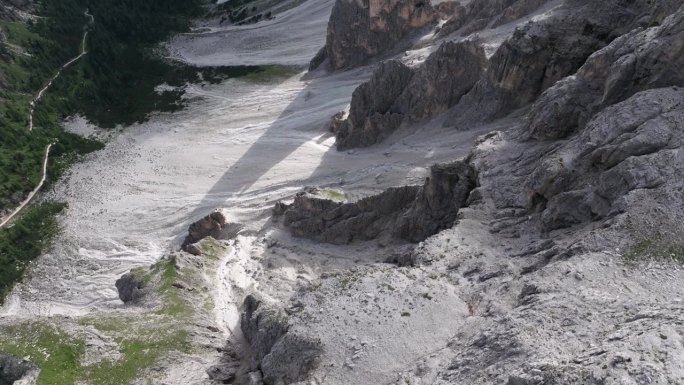 白云石岩层和小径的鸟瞰图。绿色的山谷与崎岖的山崖形成鲜明对比。