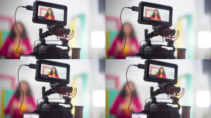 近距离拍摄一位穿着彩色衣服的女电视主持人:时尚内容创作者为她的在线频道制作视频的慢动作肖像，感谢她的