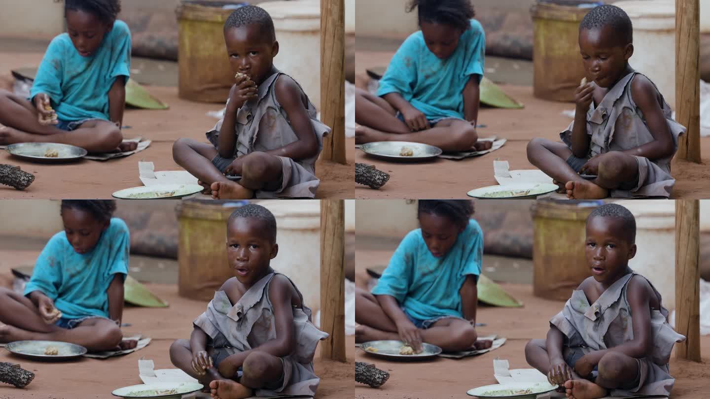 贫困，贫穷，营养不良的黑人非洲儿童由于极端贫困，干旱和气候变化。坐着吃玉米粥。五分之一的非洲儿童营养