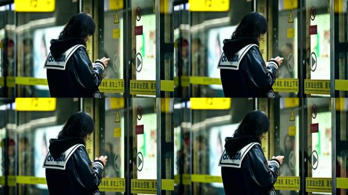 等地铁玩手机的女生