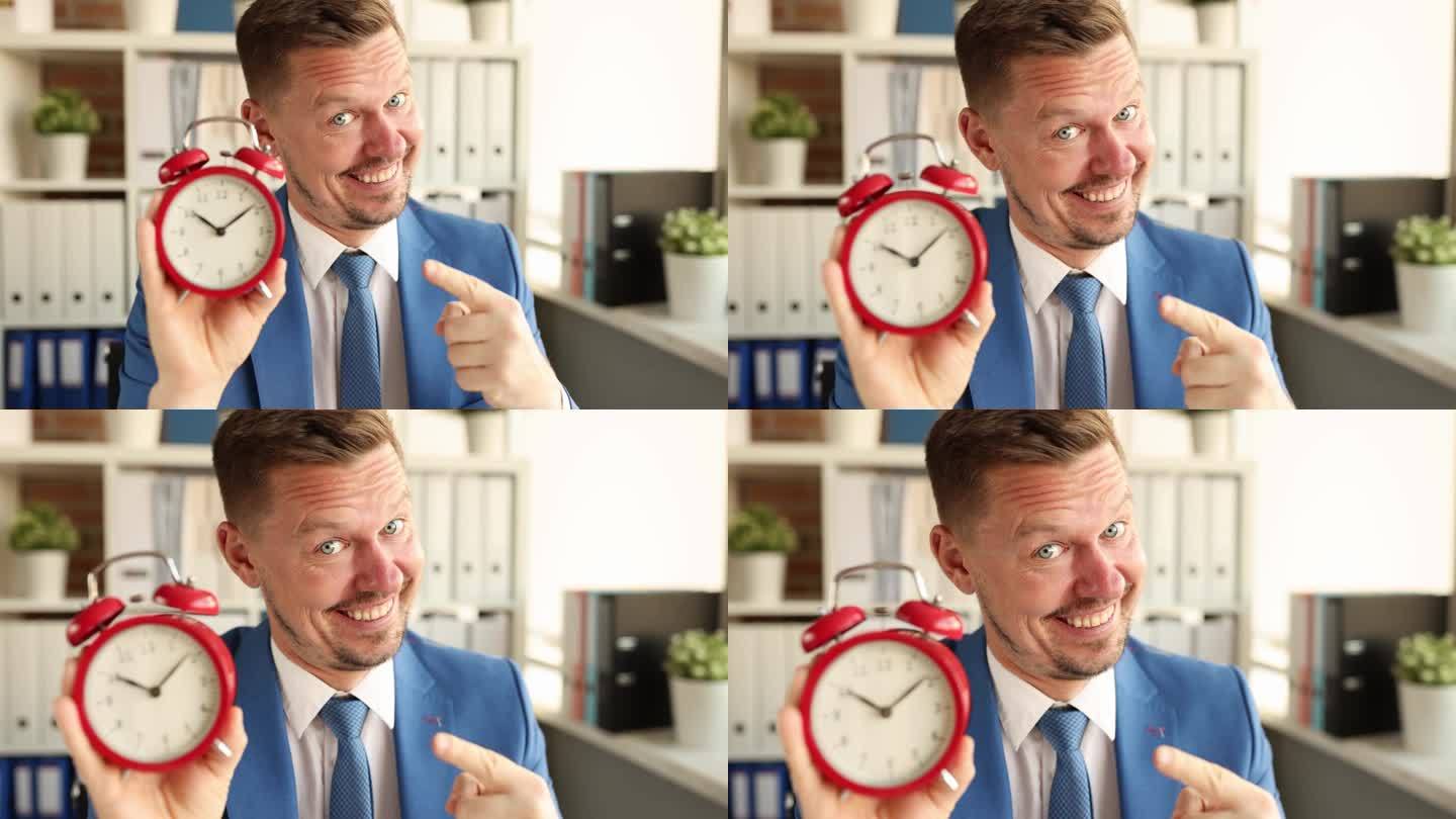 在4k电影中，微笑的经理拿着红色闹钟早上十点的画像