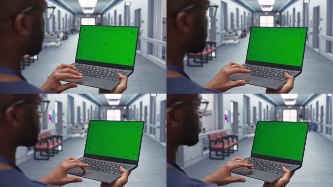 年轻的非洲男医生站在医院走廊上使用绿屏笔记本电脑。在肩膀上拍摄黑人医疗保健专业人员与病人的测试结果
