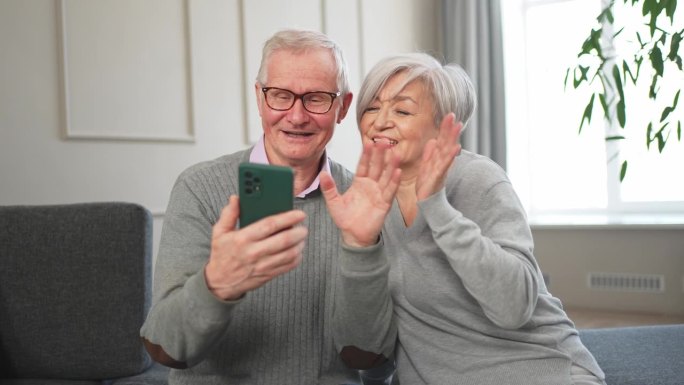 视频电话。快乐的老年夫妇，女人和男人用智能手机进行视频通话。成熟的老奶奶老爷爷在网上说话说话。老一辈