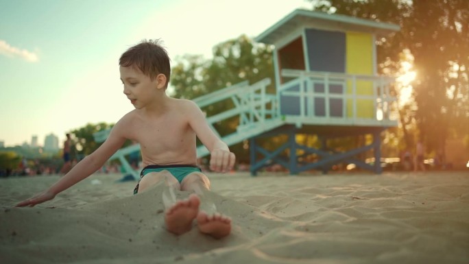 暑假里，快乐的孩子们在沙滩或海边玩沙子，埋在沙子里