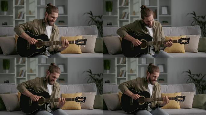 一个留着长发和胡子的男人坐在沙发上弹吉他。