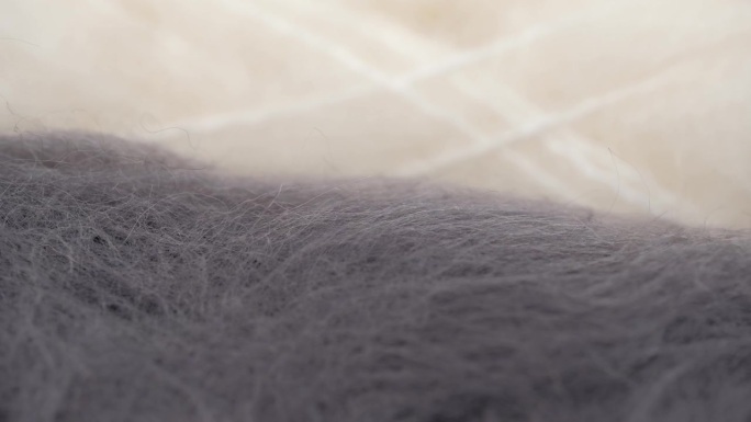 宏观视频蓬松的天然羊毛纱线在灰色和白色的颜色钩针编织和针织。旋转。