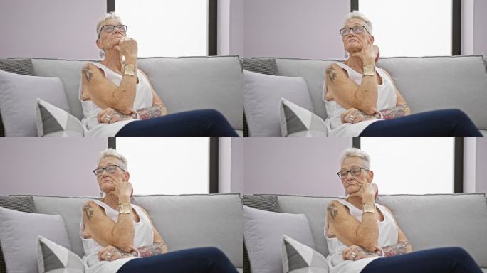 一位深思熟虑的白发老妇人坐在家里客厅的沙发上，一副严肃的表情，在思考一个烦恼或问题。