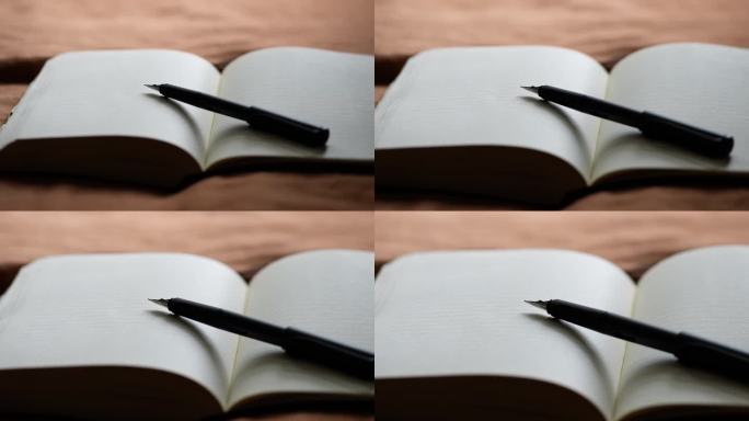 钢笔躺在空白日记本上，没有封盖。慢速放大。