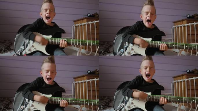 小男孩在家里弹电吉他唱歌。4k视频片段UHD 3840x2160