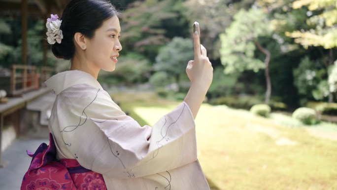 穿着日本传统和服的亚洲女士们走在日本京都的街道上自拍，并在社交媒体上分享自己的故事。