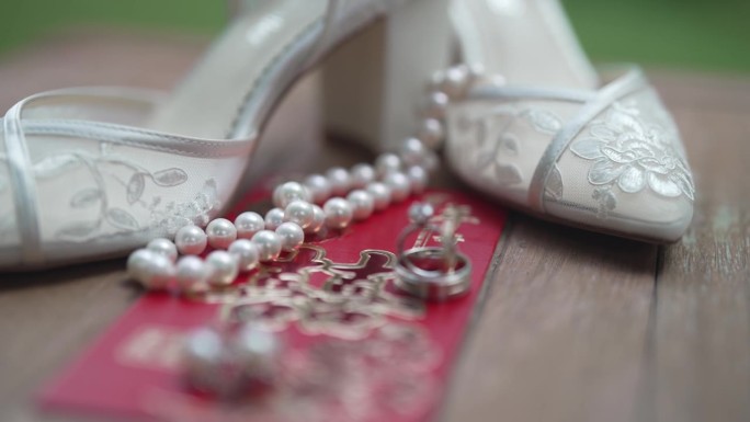 婚礼细节的美丽特写镜头，包括新娘精致的鞋子，闪闪发光的戒指，复杂的珠宝，和精致的婚礼请柬