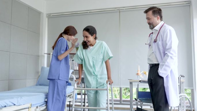 护士帮助女助行器患者接受治疗后，医生站在一旁观察，拍手打气，患者高兴痊愈，又能走路了。