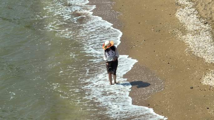 女孩走在沙滩上拍照自拍航拍
