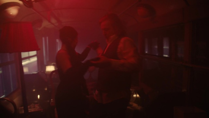 一个金发男人和一个女人在一辆旧火车上约会，车上亮着红灯