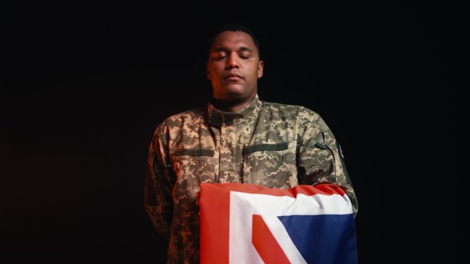 军队中身穿制服的士兵的肖像，手持英国国旗